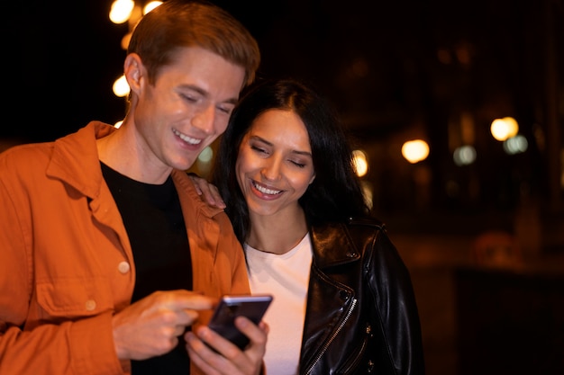 Amigos de tiro medio mirando el teléfono