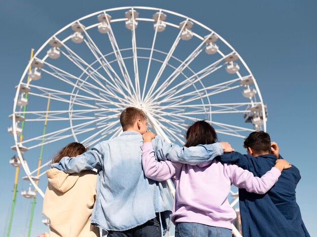 Amigos de tiro medio en el parque de atracciones