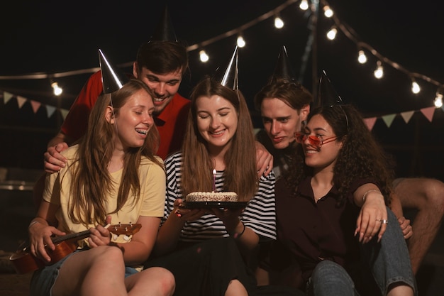 Amigos de tiro medio con pastel de cumpleaños