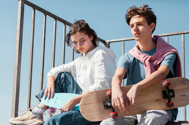 Amigos de tiro medio con patineta