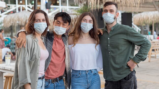 Amigos de tiro medio posando con máscaras