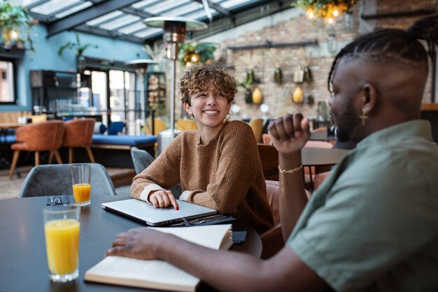 Amigos de tiro medio sentados en la cafetería.