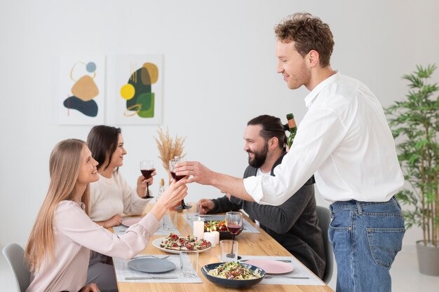 Amigos de tiro medio sentados en la mesa