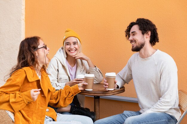 Amigos de tiro medio sentados en la mesa