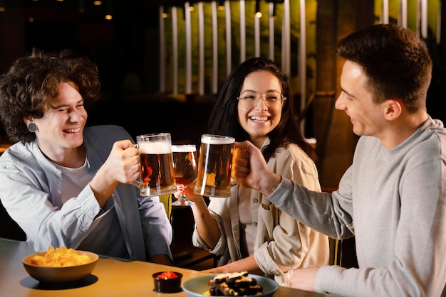 Foto gratuita amigos de tiro medio sosteniendo jarras de cerveza