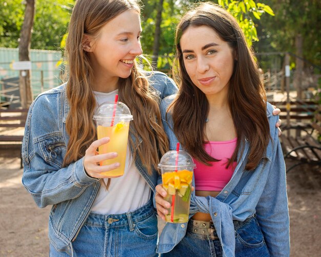 Amigos de tiro medio sosteniendo jugo fresco