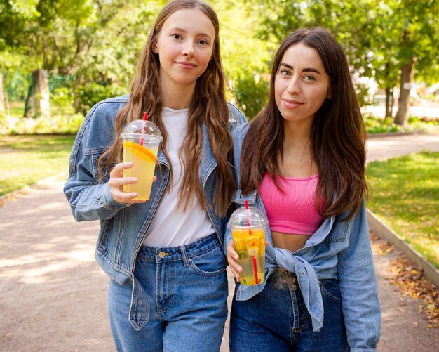 Amigos de tiro medio sosteniendo jugo fresco