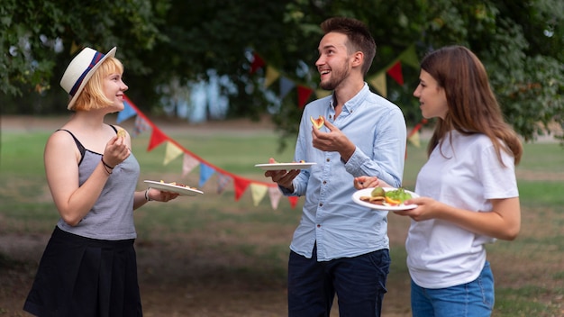 Foto gratuita amigos de tiro medio sosteniendo platos de comida