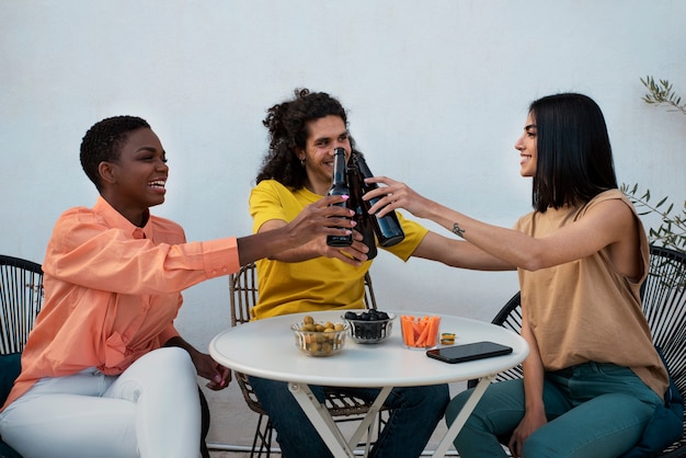 Foto gratuita amigos de tiro medio tintineo de botellas