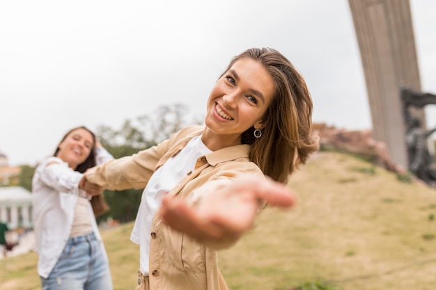 Amigos de tiro medio tomados de la mano