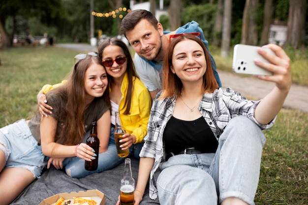 Foto gratuita amigos de tiro medio tomando selfie en la naturaleza