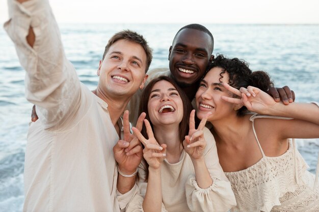 Amigos de tiro medio tomando selfie en la playa