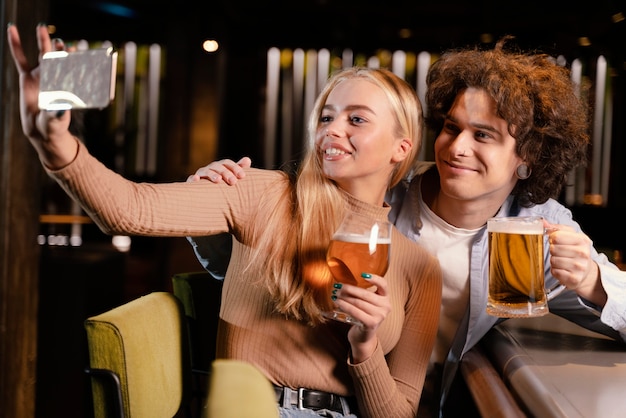 Amigos de tiro medio tomando selfie en pub