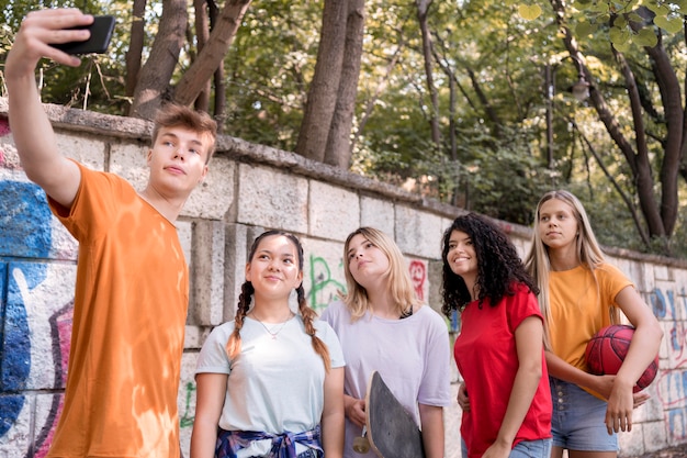 Amigos de tiro medio tomando selfies al aire libre