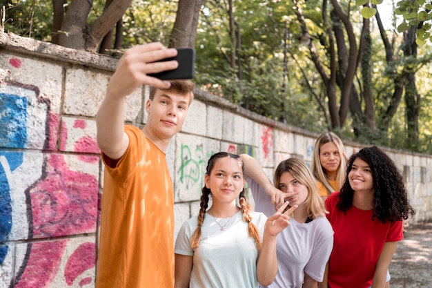 Amigos de tiro medio tomando selfies juntos