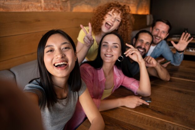 Amigos de tiro medio tomando selfies juntos