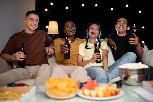 Amigos de tiro medio viendo una película.