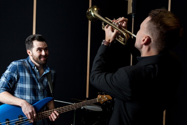 Foto gratuito amigos tocando guitarra y trompeta