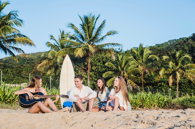 Amigos tocando música en la playa