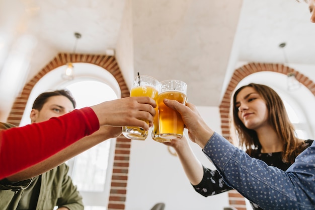 Foto gratuita amigos tomando cerveza en un restaurante