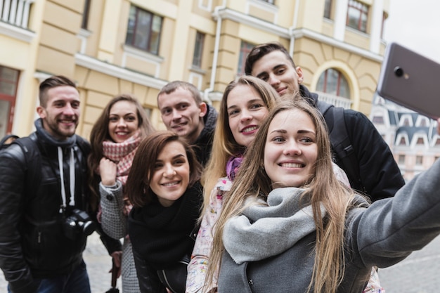 Foto gratuita amigos tomando selfie en la calle de la ciudad