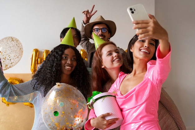 Amigos tomando selfie durante una fiesta sorpresa de cumpleaños