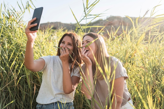 Foto gratuita amigos tomando un selfie mientras viaja en un lugar salvaje