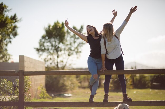 Foto gratuita amigos tomando selfie en teléfono móvil en tierras de cultivo