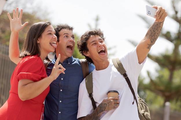 Amigos tomando selfie tiro medio