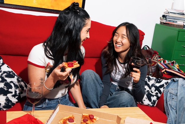 Amigos de tomas medianas comiendo pizza