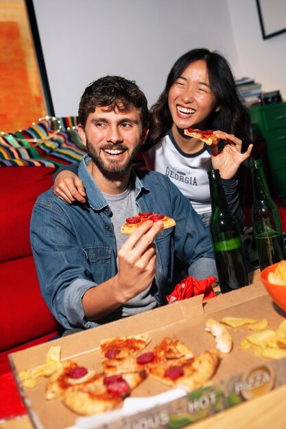 Amigos de tomas medianas comiendo pizza