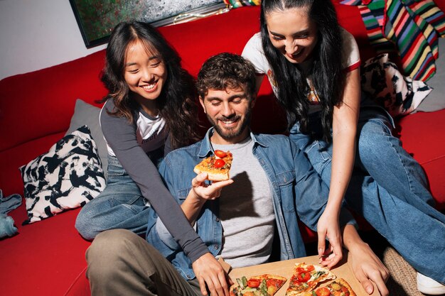 Amigos de tomas medianas comiendo pizza