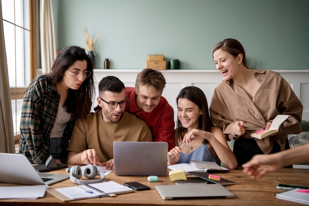 Amigos usando una computadora portátil para aprender durante la sesión de estudio