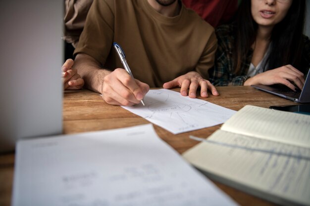 Amigos usando documentos para estudiar en una biblioteca