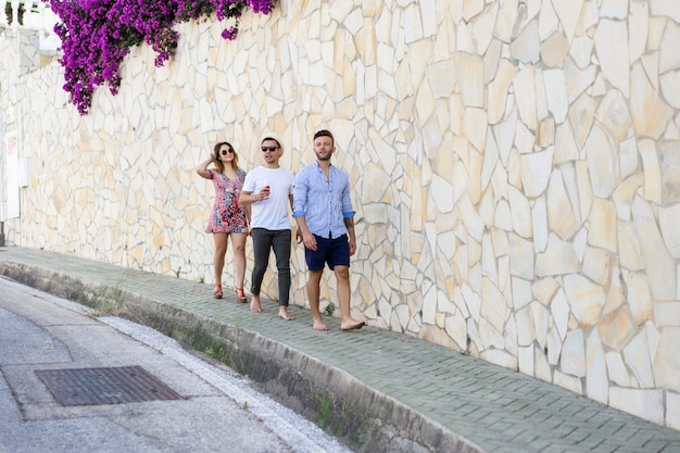 Amigos de vacaciones caminan por las calles de una pequeña ciudad europea.