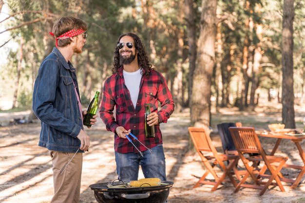 Amigos varones conversando con cerveza y barbacoa