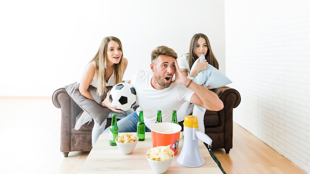 Amigos viendo fútbol en casa