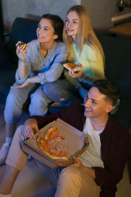 Foto gratuita amigos viendo servicio de streaming juntos en interiores