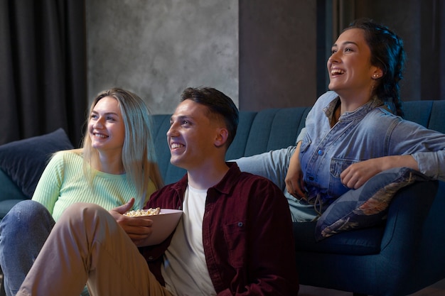 Amigos viendo servicio de streaming juntos en la sala de estar