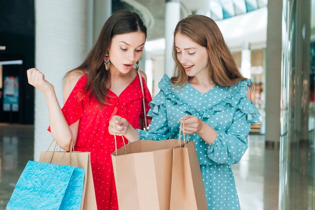 Amigos de la vista frontal con bolsas de la compra.