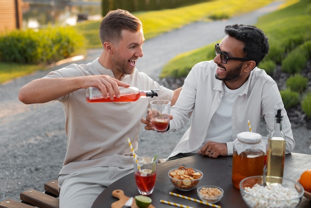 Amigos de vista frontal con deliciosa kombucha al aire libre