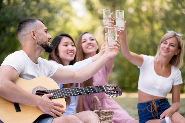 Amigos de vista frontal relajarse después de la pandemia con un vaso de limonada