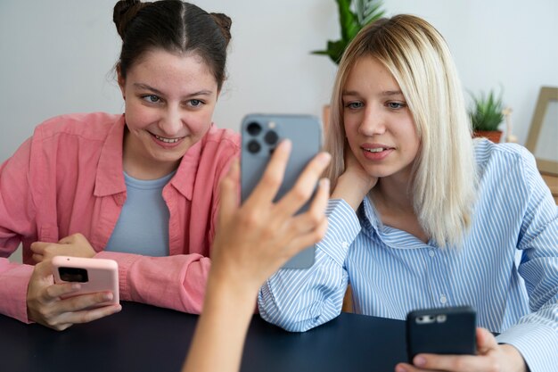 Amigos de vista frontal con teléfonos inteligentes