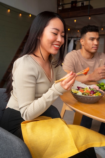 Foto gratuita amigos de vista lateral comiendo tazones de salmón