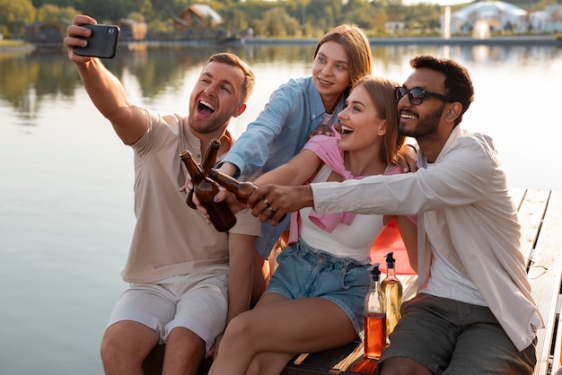 Foto gratuita amigos de vista lateral con deliciosa kombucha al aire libre