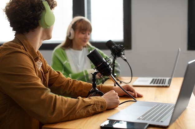 Foto gratuita amigos de vista lateral grabando podcast