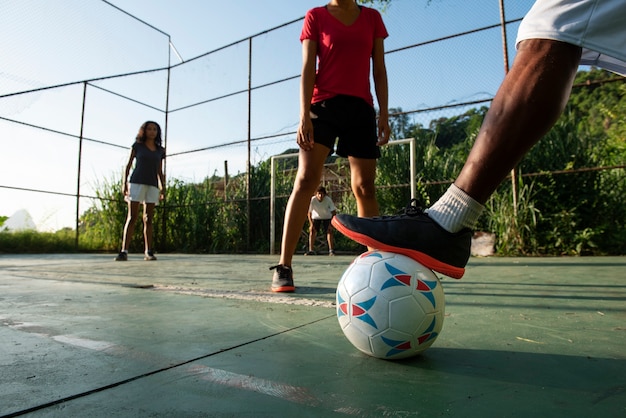 Foto gratuita amigos de vista lateral jugando al fútbol