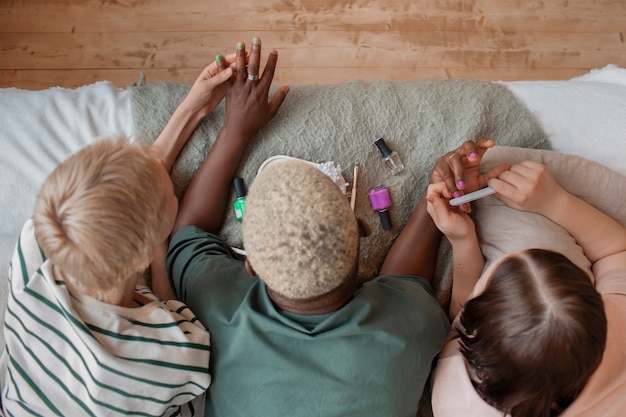 Amigos de la vista superior haciéndose la manicura