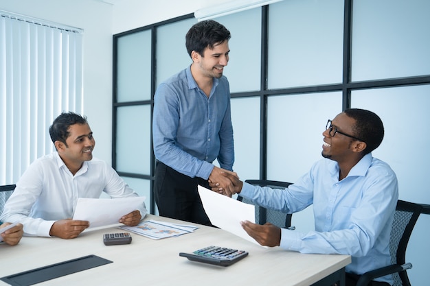 Amistosos empresarios caucásicos y afroamericanos estrecharme la mano.