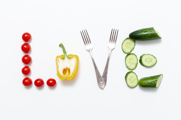 Foto gratuita amor escrito artístico con verduras y tenedores